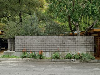 Compound Addition - Photo 6 of 12 - A wall of burnished concrete block protectively isolates their indoor and outdoor living areas from the busy road.