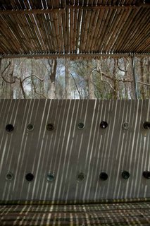 Gimme Shelter - Photo 9 of 9 - Bambooze! by Rebecca Popowsky and Riggs Skepnek<br><br>A series of circular openings made from short bamboo shoots and recycled glass bottles give the wall color and texture.<br><br>Photo by Jack Ramsdale. Courtesy of the Schuylkill Center for Environmental Education.