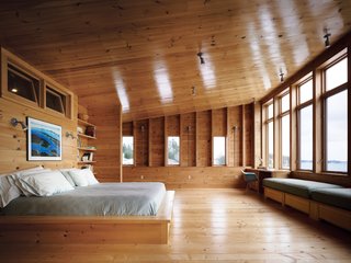 The master bedroom opens up to the sea "like a maw," says Callahan, who is delighted with the high ceilings and expansive space. Callahan and Hayes’s full-time residence in Fairfield, Connecticut, is a 1734 farmhouse with, as she puts it, "small, dark rooms and very low ceilings." Rolling drawers under the bed and window seat allow for considerable storage while keeping the room clutter-free. His-and-hers desks flank the window seat in a room one is loath to ever leave.
