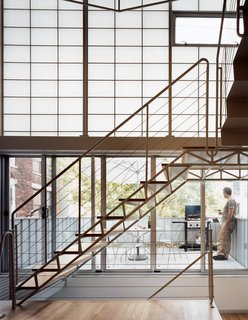 Harlem Renaissance - Photo 5 of 11 - Seemingly a single, seamless unit, the stair is composed of two elements—treads and mezzanine—and held in place by two distinct strategies: The stairs are welded to, and cantilever out from, a series of steel tubes concealed in the walls; the mezzanine <br><br>is attached on one side to a steel beam, and hung at two other points from rods attached to the roof structure.