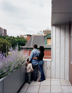 Harlem Renaissance - Photo 10 of 11 - Yvette, Adrian, and their son Julian survey the view from the top-floor terrace. "I’ve never been fond of modernism—I find it cold," Adrian admits. "But having this house, I have <br><br>to say, it’s growing on me."