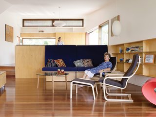 Pedigree Charted - Photo 3 of 10 - Hannah Ferguson relaxes in her living room. Her daughter Joanna prepares dinner in the open kitchen, behind and above the plywood banquette designed by the architects.