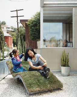 Téa gets mom ready for her close-up on the curvy nature-meets-industry chaise lounge of the architects’ own design. The landscaping in front and out back is characterized by sturdy, resilient, and drought-resistant plants like bamboo and cacti, cultivated in galvanized steel planters.