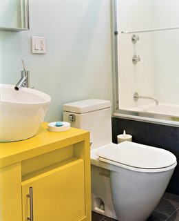 To save money and time, the architects used similar designs for the bathrooms<br>in both their and Andy’s apartment: Philippe Starck toilets, fixtures from New York’s AF Supply, and custom cabinets painted with watertight auto-body paint.