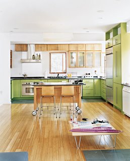 Knowing that Andy’s multi-tasking begets clutter, John provided him with plenty of cabinets. By making very particular requests of The Home Depot—asking for irregular-sized doors and painting them electric green—John defied the generic look of big-box cabinetry.