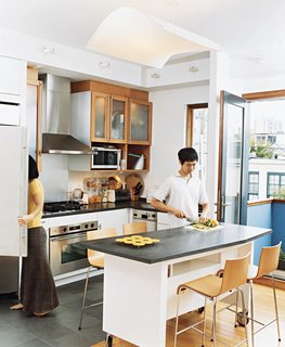 Avid cooks, Jinhee and John spend part of every day around their custom-built kitchen<br>island, surrounded by Compasso d’Oro barstools. An edamame plant on their patio occasionally provides leaves for Korean dishes.