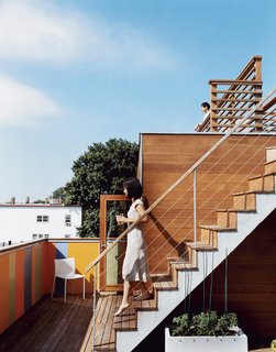 Jinhee and John, looking east from the dual-story roof deck. The door behind Jinhee leads to the top floor of Andy Hong’s unit, where a bar fridge contains wine ready for parties. In the background is the boxy form of a traditional triple-decker.