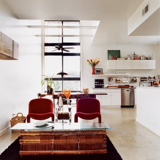 In the living room, a coffee table adapted from old piano parts meets vintage red Alky chairs by Giancarlo Pirette for Castelli.