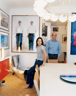 Didier Krzentowski and his wife, Clémence, in the dining room of their Paris flat. The Slim table was designed by Martin Szekely for a Galerie Kreo exhibition in 1999. On the wall, above a Marc Newson Alufelt chair, is a photograph of Krzentowski by Erwin Wurm.