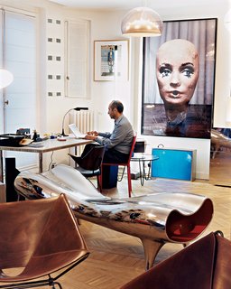Krzentowski, who works from home for three hours a day, at his desk. A Marc Newson Orgone stretch lounge occupies the foreground, while a large Paul McCarthy photograph looms behind.