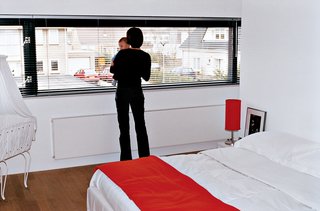 Dedy gazes out at the neighborhood from the couple’s bedroom.