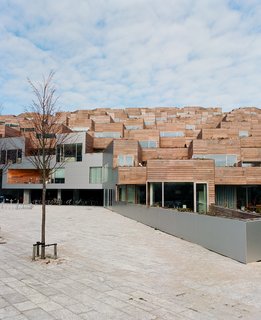 The wood-clad balconies of the private side of the building offset the futuristic punched-metal mural of Mount Everest on the facades facing the Metro tracks. "It's a schizophrenic sensibility," Ingels says. "The south is purely organic, and the north is strictly contemporary."