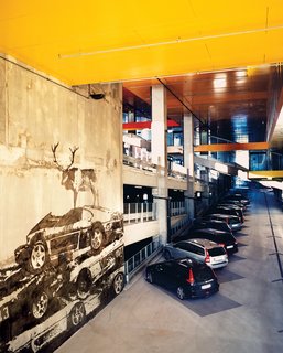 Not content to just build a regular parking lot behind the Himalayan facade, Ingels created a high-ceilinged, five-story, concrete-and-steel "car cathedral—to celebrate car culture." Throughout, the French artist Victor Ash varnished the concrete walls with gray-on-gray murals of wild animals—a wolf, a moose—standing atop piles of wrecked automobiles.