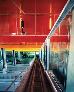 The halls connecting the garage to the residences are covered in brightly painted aluminum treatment associated with cars, not buildings. The colors move, symbolically, from earth to sky: green, yellow, orange, dark orange, hot pink, purple, bright blue. "Buildings are never brightly colored," says Ingels, explaining the thinking behind this stepladder rainbow, "but cars often are."