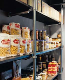 Hoagies' Heroes - Photo 11 of 13 - "We said to Grupo 7, ‘We need you to use the cheapest materials possible, but in a really cool way,’" Mazza recounts. Chain-link fence poles hold up the racks of food in the market and support the grid of lights on the ceiling.