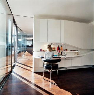 The Penthouse Has Landed - Photo 3 of 16 - The biggest challenge for the architects in building House Ray 1 was to create a home for themselves. They transformed the ideas of their architectural philosophy into the architectural reality of each detail, designing each element of or within the house on their <br><br>own, ranging from door handles to the light switches to the furniture. Here we see the view from daughter Nora’s bedroom down the length of the penthouse interior.