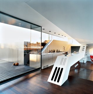 The Penthouse Has Landed - Photo 7 of 16 - The "culinary cockpit" (a.k.a. the kitchen) stands at the center of the apartment on a raised platform. A long, white slanted counter contains hi-fi speakers and a BUS-system panel of 18 buttons for controlling lights, curtains, heating, ventilation, etc.