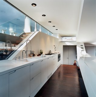 The Penthouse Has Landed - Photo 9 of 16 - The kitchen window looks out to stairs that lead up to a small roof terrace. The kitchen faucet is byDornbracht. The recessed lighting is by Guzzini.