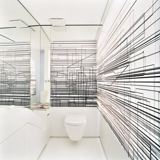 The Penthouse Has Landed - Photo 12 of 16 - The walls of the toilet room are decorated with an abstract composition of overlapping black lines printed on a screen that is lit from behind.