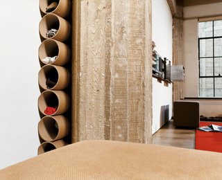 In the bedroom, mailing tubes tucked between a concrete weight-bearing post and the eastern wall serve as substitutes for a chest of drawers.