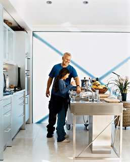 Picard and his daughter, Alexis, who visits on weekends, enjoy cooking fresh ingredients like fish or artichokes in the Miele steam oven. The translucent glass wall provides plenty of natural light and gives the aluminum-and-stainless-steel kitchen a soft white glow.
