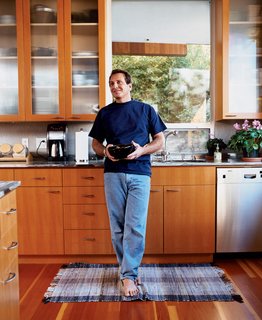 The architect at home in his kitchen with cabinetry that he also designed.