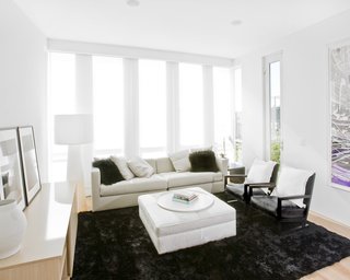 At the end of the kitchen opposite the dining room is the family room. It looks back to the kitchen and acts as a breakfast nook on a day-to-day basis and provides an intimate area for smaller, more casual entertaining. Hollis used a black silk and wool shag rug from ABC Carpet to pull together the Casa Milano sofa, and B&B Italia lounge chairs and ottoman.Photo by <br><br>Ben Mayorga Photography