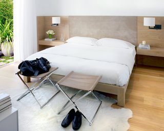 The master suite was relocated from the upper level to the lower level to separate public and private spaces. Hollis designed the custom white-oak bed and suite headboard with built-in bedside tables (fabricated by B Serota Furniture and Architectural Design and upholstered by Kroll Furniture) and opened the room to the backyard garden to extend the space.Photo by <br><br>Ben Mayorga Photography