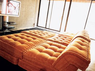 A comfy set of nine interlocking orange throw pillows from Roche Bobois fills the downstairs television room.
