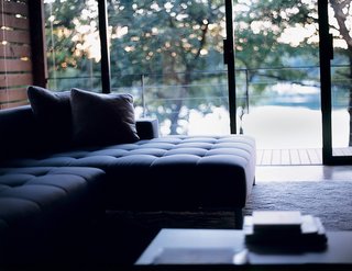 Each of the house’s three sliding patio doors was positioned to frame panoramic views of Moose Lake, so it was important that the furniture wouldn’t get in the way. The pieces chosen were just right: A low-lying couch and armchair, both by Luminaire, hug the living room floor. A square coffee table, also by Luminaire, sits less than a foot off a blue shag rug.