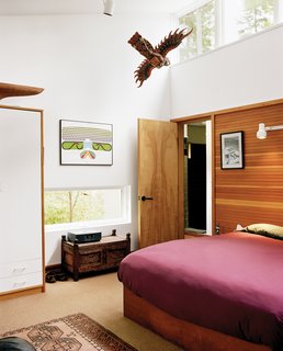 Cohen's bedroom is clipped onto one end of the house, just across from Sally’s bedroom. A door to the left of the bed leads into his spacious bathroom, where he cleans up after long, muddy hikes in the woods with his golden retriever, Daisy.