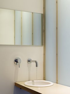 Because the upper-level bathroom is in the middle of the upper level, without a window, Willmer and her team--including designers Kathleen Heimerman and Joseph Barajas--created one wall with a translucent material to bring a lightness and glowing affect to the room. <br><br>Photo by Ken Gutmaker