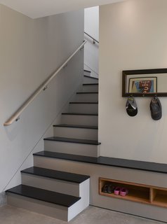 Entering the home through the garage, the rest of the house is accessed through the mudroom, which leads up the stairs to the public level or straight through to the bedrooms and backyard beyond. The third stair from the bottom extends into a bench for putting on and taking off shoes. "It was a nice opportunity to make the stairs sculptural and integrated into the space," Willmer says.<br><br>Photo by <br><br>Ken Gutmaker