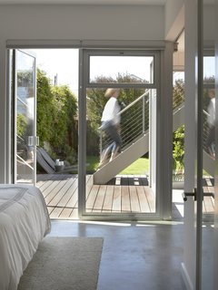 The couple couldn't afford to add another story for a master suite so they agreed to move their bedroom to the ground level with the other private areas. Their room opens to the backyard for now, but Willmer installed plumbing upstairs in case one day they are able to build up.<br><br>Photo by Ken Gutmaker
