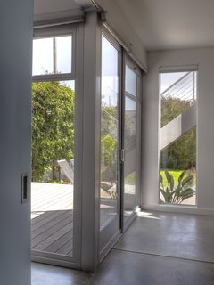 The blue door on the left separates the kids' bedroom (right) from the couple's room. When open, the joined areas give the ground floor a more spacious feel. If Katie and John do build an upper-level master suite in the future, the two rooms can become two kid's rooms or a play room and a sleeping room.<br><br>Photo by Ken Gutmaker