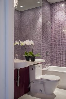 The main-level bathroom is finished quite similarly to that of the master suite: an Arcitec sink and Stark 2 toilet by Duravit, a crystal sconce by Eurofase, and tiles by Bisazza.<br><br>Photo by <br><br>Sharon Risedorph