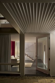 Before the renovation, the bottom floor consisted of dark, unfinished rooms. To brighten the space and create an extension of the public areas above, Samaha and Hart extended the stairwell to the bottom floor and created a cantilevered deck to eliminate barriers that would obstruct light from infiltrating the space.<br><br>Photo by <br><br>Sharon Risedorph