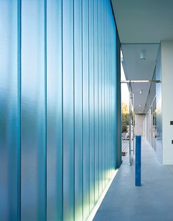 Walls of channel glass, an industrial material that comes in long strips shaped in a shallow U, help preserve the residents’ privacy, while allowing only soft, filtered light inside. In the chapel, the DeBartolos paired and staggered the narrow panels so that only the most opaque light comes through. Obscure views and the most basic shapes and colors from outside create a glowing, ethereal quality indoors. Holy water is held in an elegant blue glass cylinder.