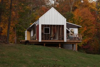 Red and yellow accent colors blend with natural North Carolina foliage. Cantilevered porches and decks provide deep shadows. Image courtesy Chad Everhart Architect.