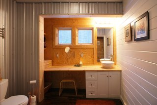 The vanity in the bath is housed in what Chad calls a "bump-out" or a saddlebag, a feature that expands interior space by a few feet on either side of the farmhouse. Image courtesy Chad Everhart Architect.