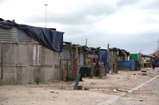 In September 2007, Luyanda Mpahlwa, principal of MMA Architects, designed a two-story house with these factors in mind for Design Indaba’s 10x10 Low-Cost Housing Project. The program tasked teams to create attractive, affordable housing schemes using innovative solutions. Pictured here is the Cape Town township before Mpahlwa’s sand-based buildings were constructed. <br><br>Image courtesy Interactive Africa/ Design Indaba