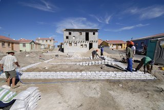 Before building the framework of the house with pine timber and galvanized metal, the workers piled sandbags on the ground to map out the home’s foundation. Image courtesy Interactive Africa/ Design Indaba