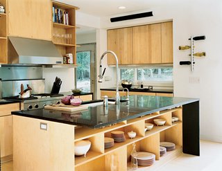 Wieler and Tung wanted a space conducive to entertaining, and this open kitchen delivers. It features a stainless steel refrigerator, Pro-Style gas range, hood, backsplash, and two-rack tub dishwasher, all from Jenn-Air. The ebony countertop, which allows the chef to interact easily with guests, is from Caesarstone. The distinctive faucet and Poise kitchen sink are from Kohler. Maple cabinets by Merillat (installed flush with the wall to save space and look sleek) provide ample storage space for all kitchen essentials. The under-counter storage space holds Victoria china designed by Oscar Tusquets for Driade. The bread board was designed by Antonio Citterio for Iittala’s Tools collection. The wine rack and oil/vinegar cruets are from Rosendahl.