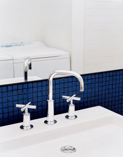 The bathroom does double duty as the laundry room. Sink, faucet, and all other bathroom fixtures throughout the house are by Kohler. The Eco-Smart washer and SmartLoad dryer are by Fisher & Paykel.