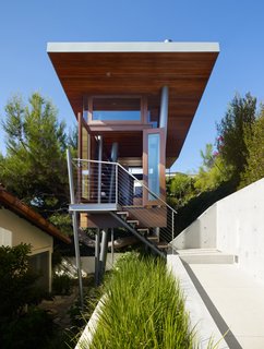 A clerestory around the perimeter of the butterfly roof gives an illusion that the roof floats over the box of the treehouse.