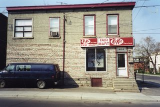 The building, as it appeared when the owners bought it in 2001. Behind the brick wall at left, the architect and owners found another window, which was reopened. The building has held a confectionery, a general store, a rooming house and a post office.