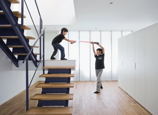 Small Box Home with Black Metal Facade in Japan - Photo 12 of 14 - The open-tread stair leading from the garage to the second-floor living room sets the stage for a Star Wars–style duel.