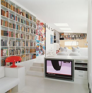 The Aarnios’ living room includes a wall of magazine covers featuring the designer’s work and a pair of white Pony chairs, Aarnio’s 1973 design.