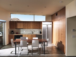 Small "Hybrid Prefab" Home in the Desert - Photo 4 of 10 - One large room houses the kitchen, dining, and living area; the backsplash and countertops are made by Vetrazzo.
