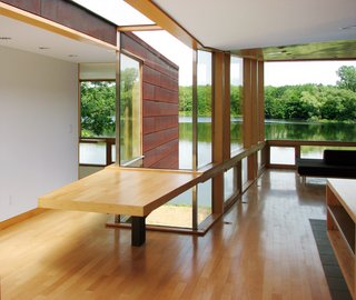 The cross-section of the X, just off the kitchen, is outfitted with a cantilevered multi-use table and topped by a glass connector above. "This makes the building seem larger, allows the outside to come in and makes for an interesting situation architecturally," says Garrison.